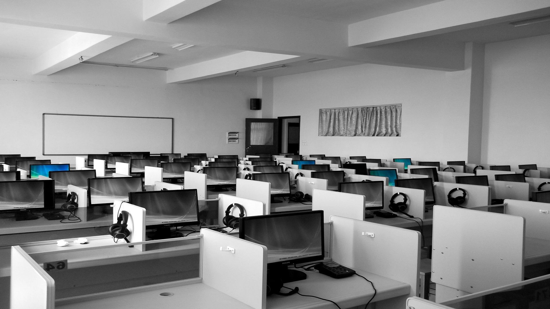 Help desk cubicles — rows of support workstations with headsets ready