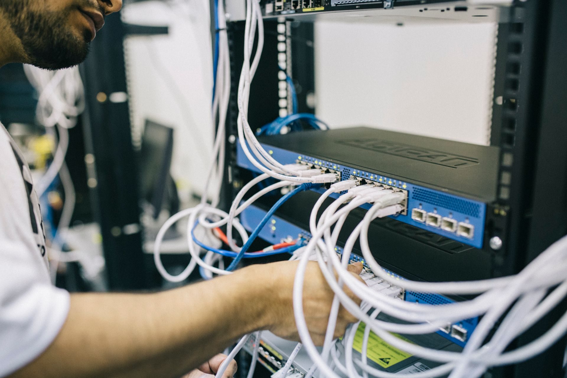 A technician patching cables into a network switch